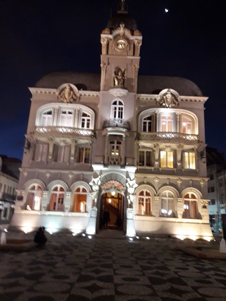 Fachada ecléctica con una torre del reloj iluminada por la noche en el centro de Curitiba