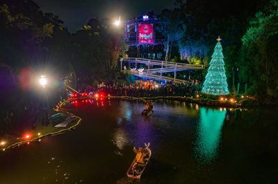 Árvore de Natal iluminada à beira de um lago em Curitiba