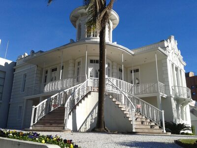 A historic white mansion with a tower in downtown Curitiba